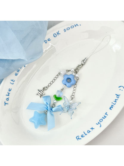 Blue tone flower bow keychain displayed on a wooden surface