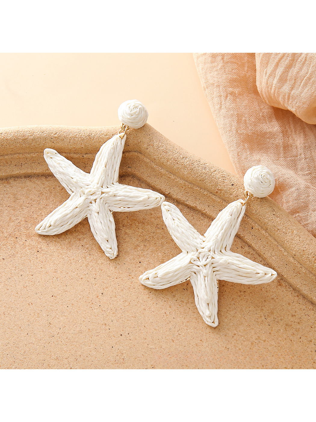 Detailed view of the woven raffia pattern on the starfish stud earrings