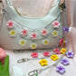 Minimalist flower pendant bag charm with gold chain on white background