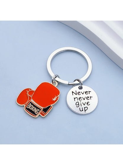 Alloy boxing glove keychain attached to a set of keys on a wooden surface