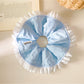 Blue ruffle scrunchie wrapped around a ponytail in brown hair