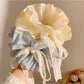 Gifty solid color bow scrunchie in pastel blue displayed on a wooden surface