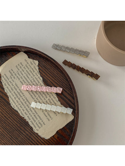 Beau chic small square hair clip held between fingers displaying size and shape