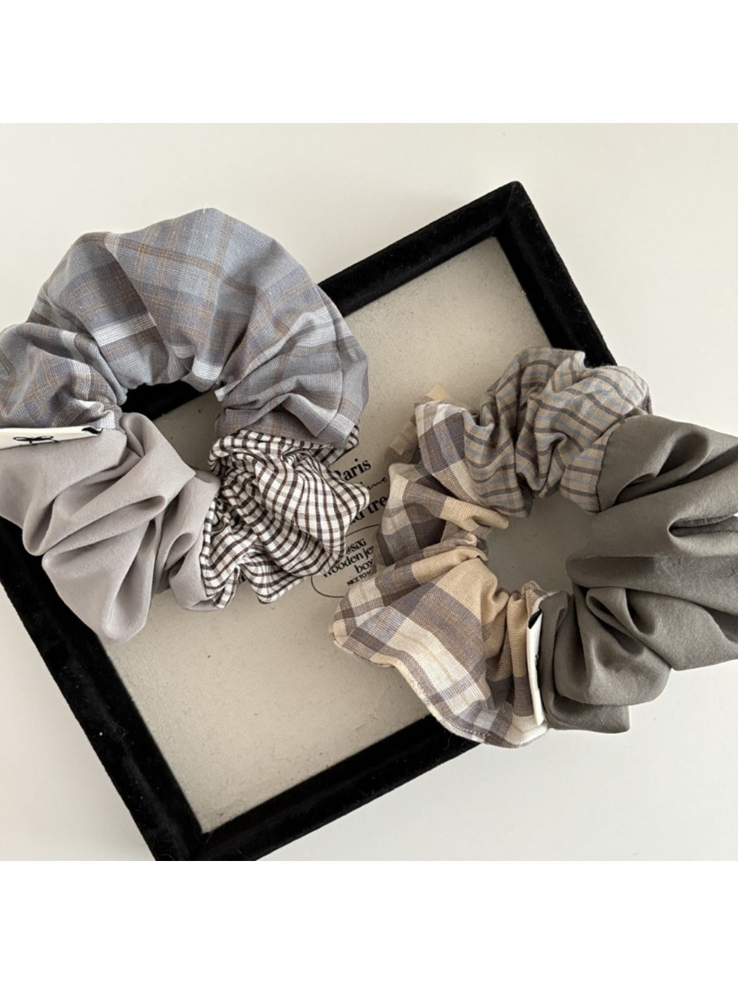 Close-up of Gifty vintage plaid patchwork scrunchie with mixed fabric patterns