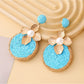 Earedge earrings photographed with soft lighting emphasizing gold floral circles