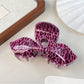 Beau claw clip with leopard print bow design styled in hair