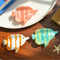 Beau tropical fish hair clip held in hand to show size and color variations