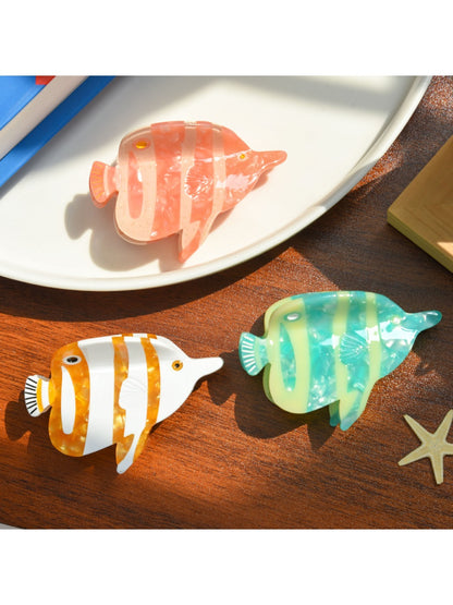 Beau tropical fish hair clip held in hand to show size and color variations