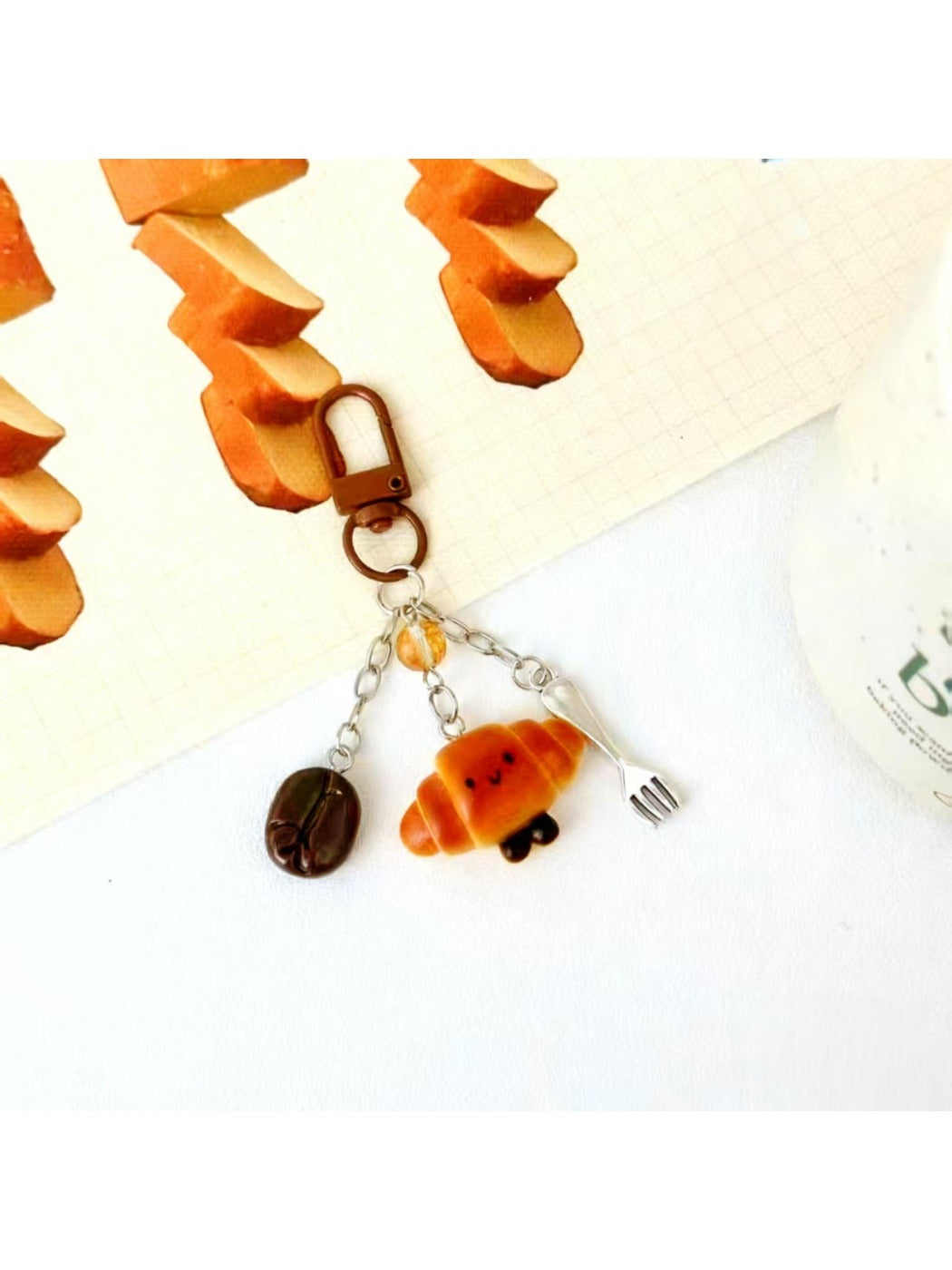 Mini baguette keychain held in hand to show size and scale
