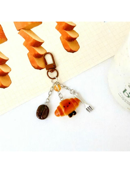 Mini baguette keychain held in hand to show size and scale
