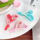 Close-up of Beau heart shaped claw clip showing smooth plastic texture and color contrast