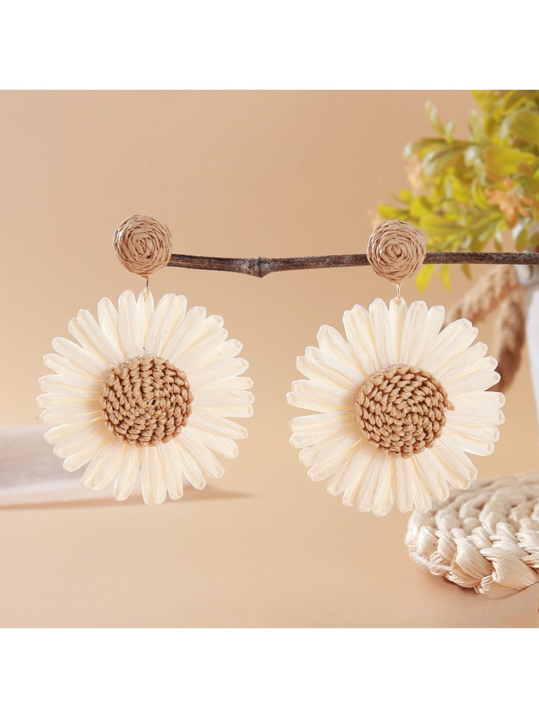 Flat lay of vintage raffia sunflower earrings with natural elements like dried flowers