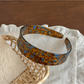Gifty acetate headband placed on a wooden surface with natural lighting