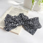 Striped bow scrunchie styled on a wrist as a bracelet accessory
