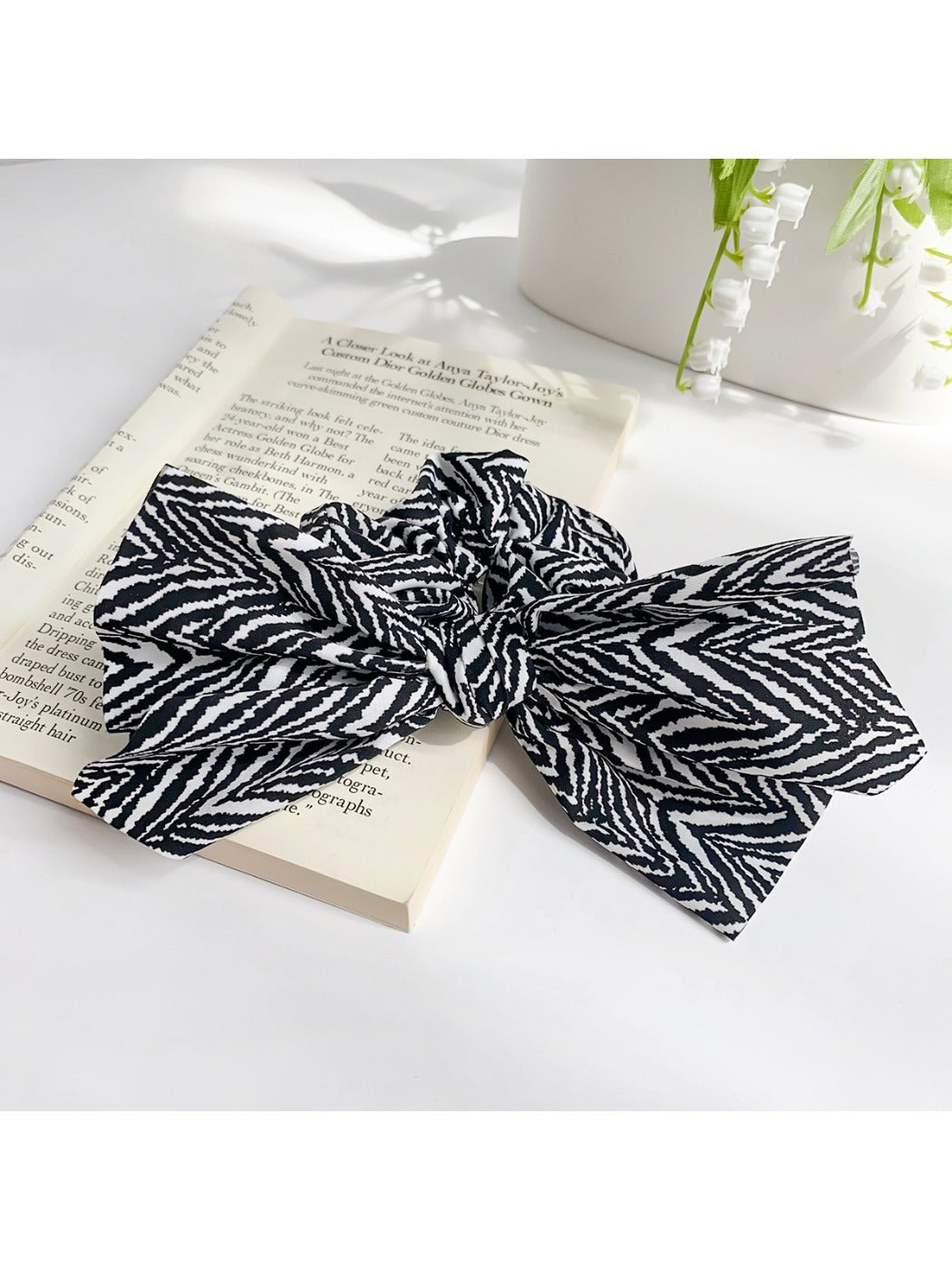 Striped bow scrunchie styled on a wrist as a bracelet accessory