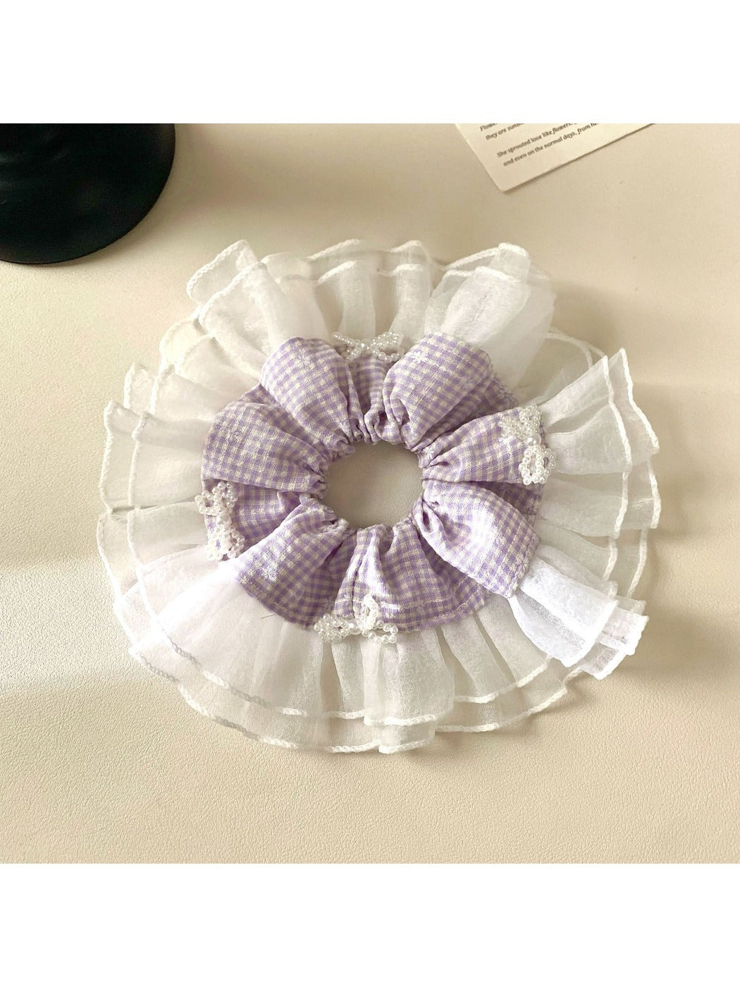 Gifty plaid scrunchie styled on a wrist as a fashion accessory