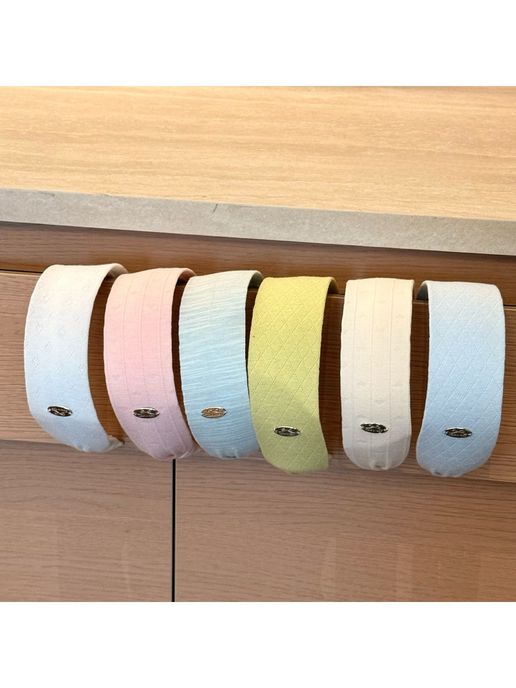 Gifty headband displayed flat highlighting its wide design and solid color