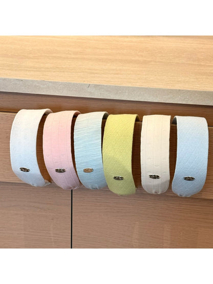 Gifty headband displayed flat highlighting its wide design and solid color