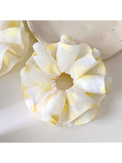 Close-up of yellow polka dot scrunchie fabric texture