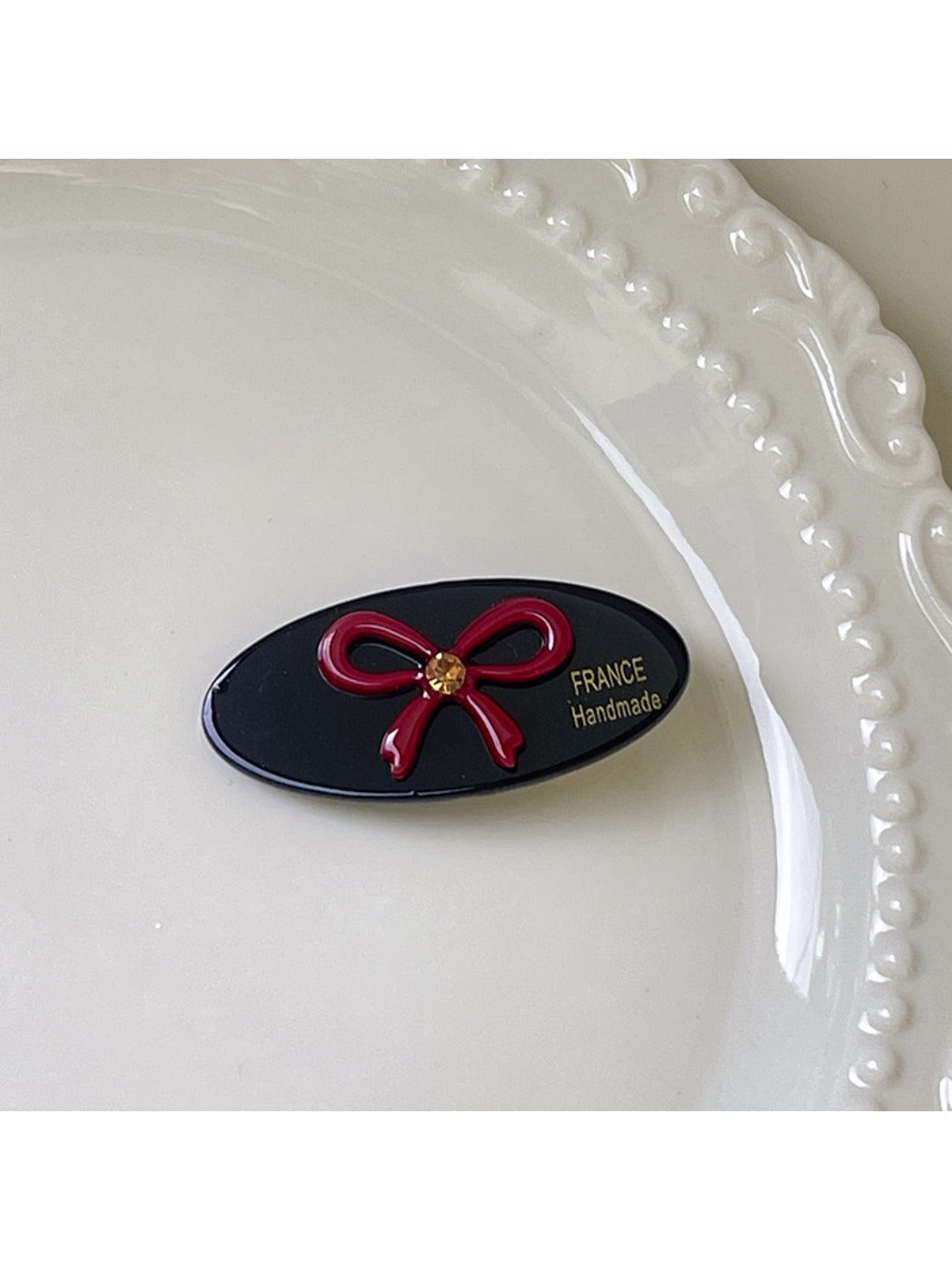 Top view of beige oval butterfly hair clip on a flat surface