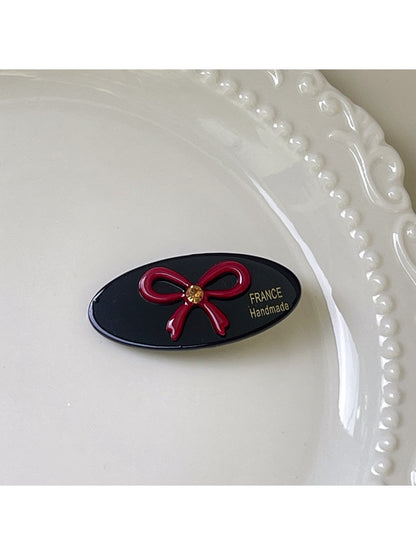 Top view of beige oval butterfly hair clip on a flat surface