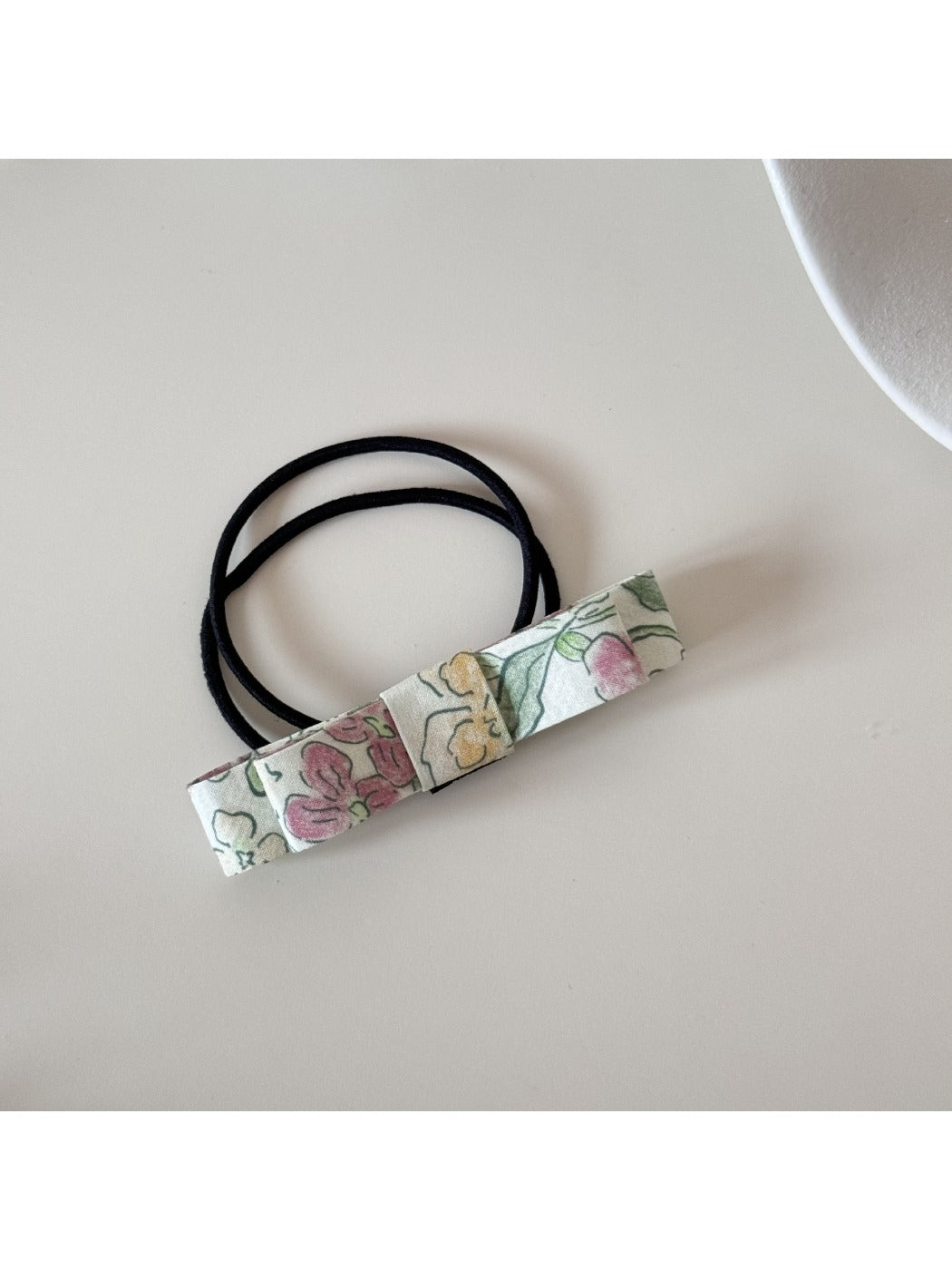 Flat lay of multiple pink bow hair ties arranged neatly on a light background