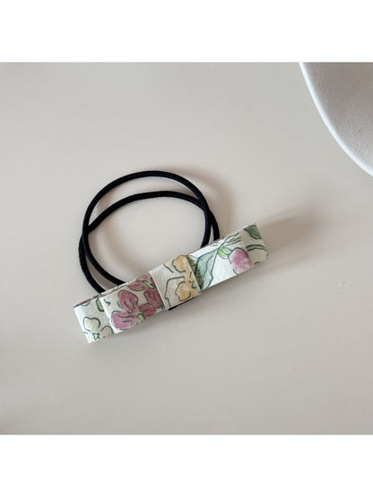 Flat lay of multiple pink bow hair ties arranged neatly on a light background