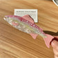 Beau elegant salmon shaped hair claw clip placed on wooden surface