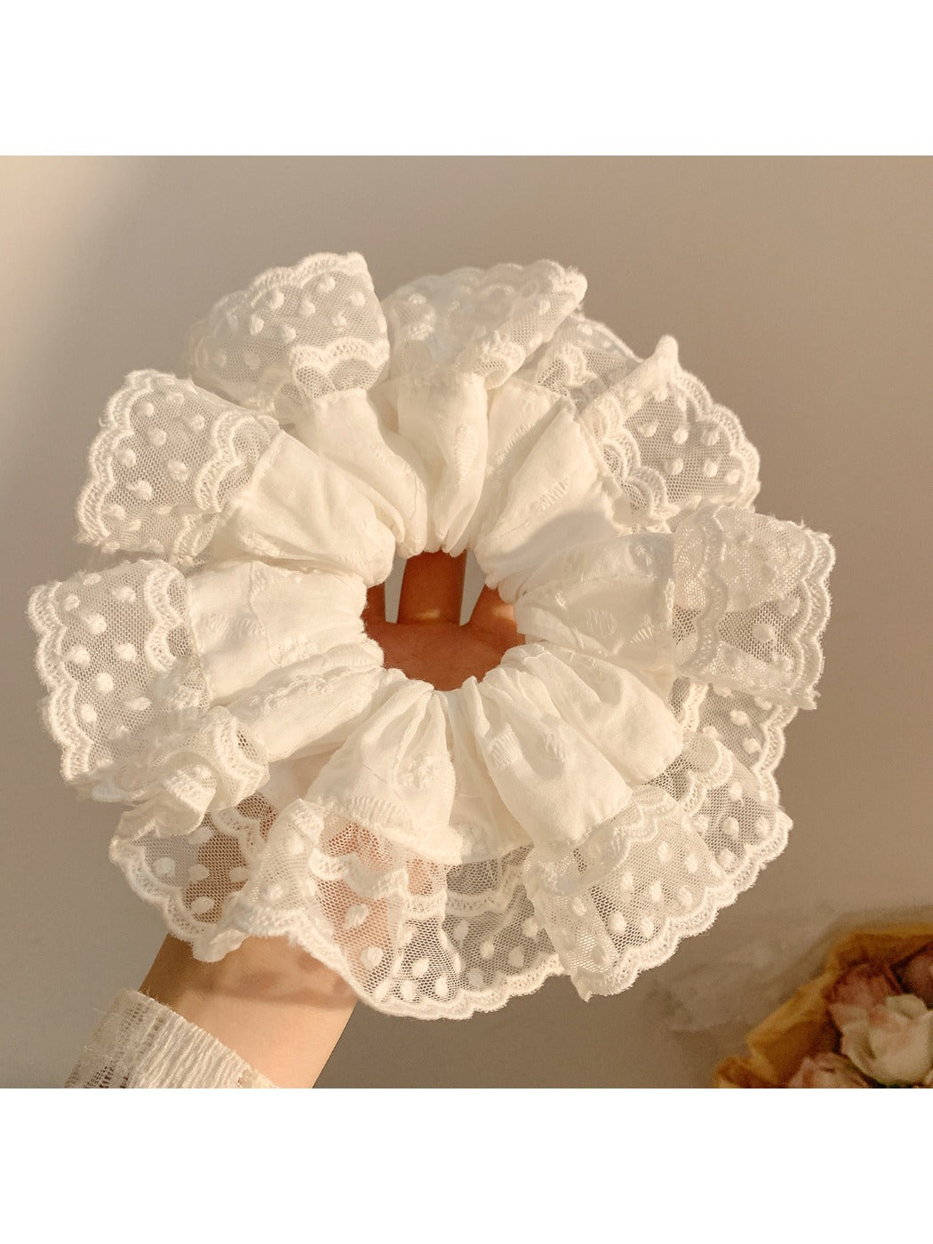 White ruffled scrunchie holding a ponytail in a natural hair setting