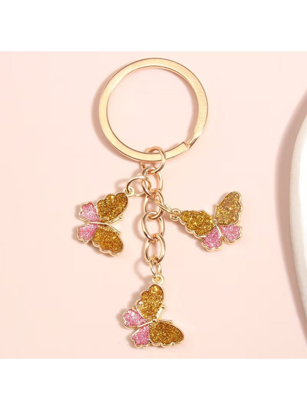 Butterfly keychain hanging from a bag zipper with colorful segmented wings