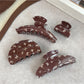 Beau claw clip showing butterfly pattern and curved design
