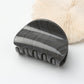 Beau half circle hair clip styled in a low ponytail on dark hair