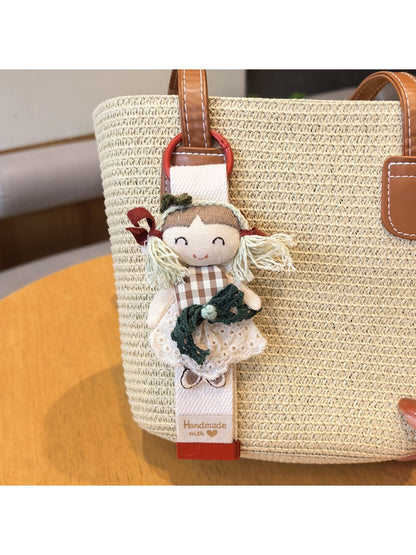 Keypus cute girl charm keychain hanging from a set of keys on a wooden table