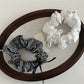 Gifty Sweet Bow Stripe Scrunchie worn on a wrist as a fashion accessory