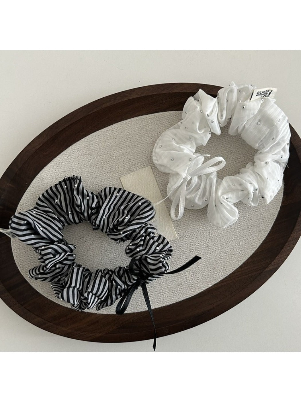 Gifty Sweet Bow Stripe Scrunchie worn on a wrist as a fashion accessory