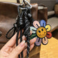 Rainbow sunflower keychain hanging from a set of keys on a wooden surface