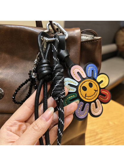 Rainbow sunflower keychain hanging from a set of keys on a wooden surface