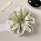 Green lace scrunchie with fresh floral pattern on a white background