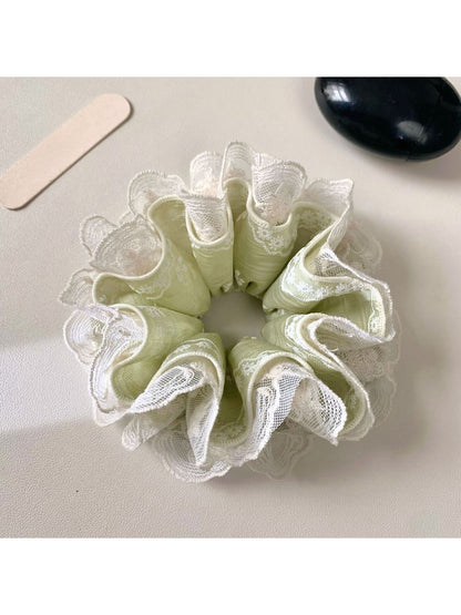 Green lace scrunchie with fresh floral pattern on a white background