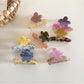 Beau flower shaped hair clip displayed on a white background showing its glossy acetate finish
