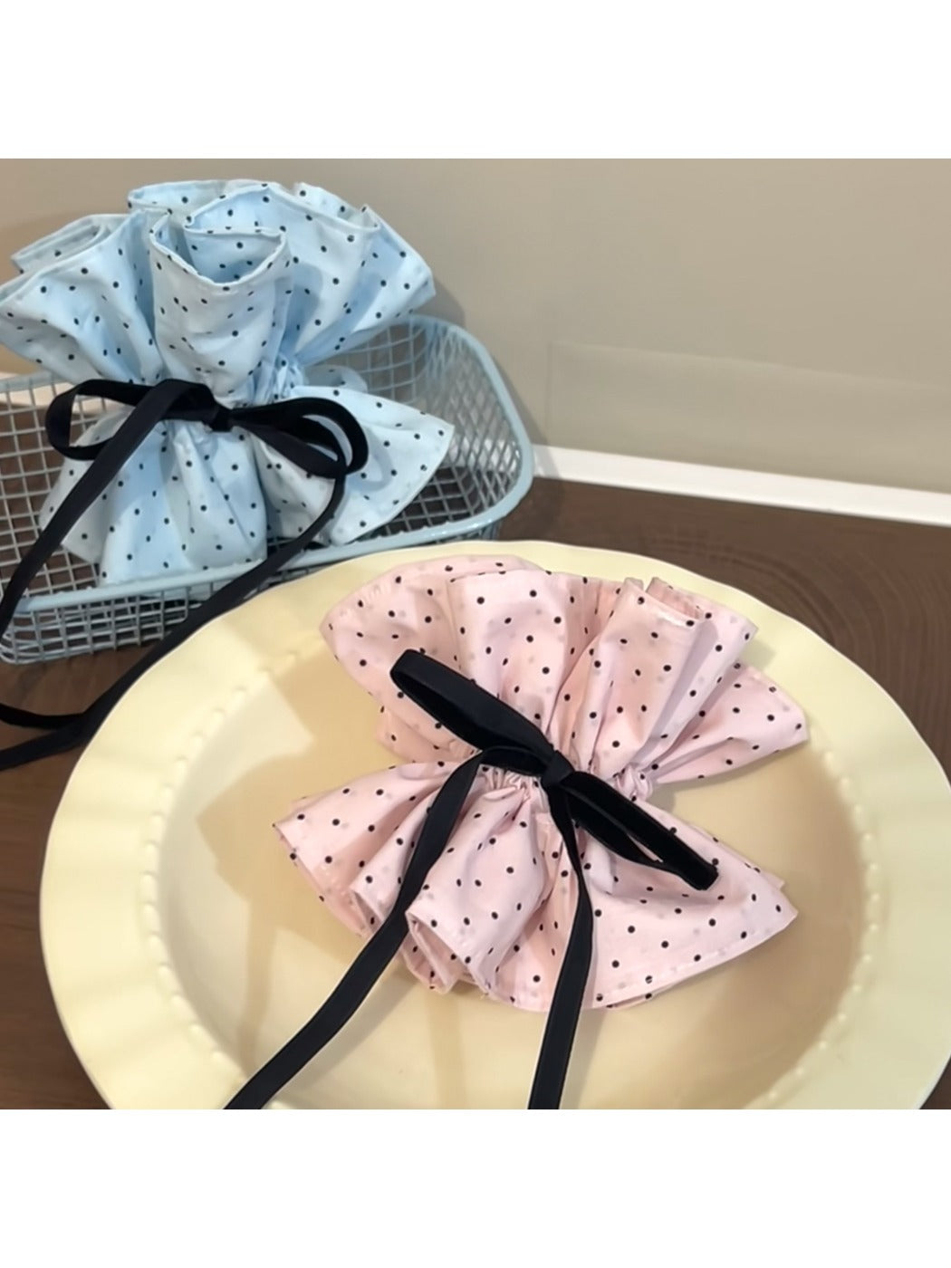 Close-up of Gifty sweet polka dot bow scrunchie in soft pink fabric with white dots