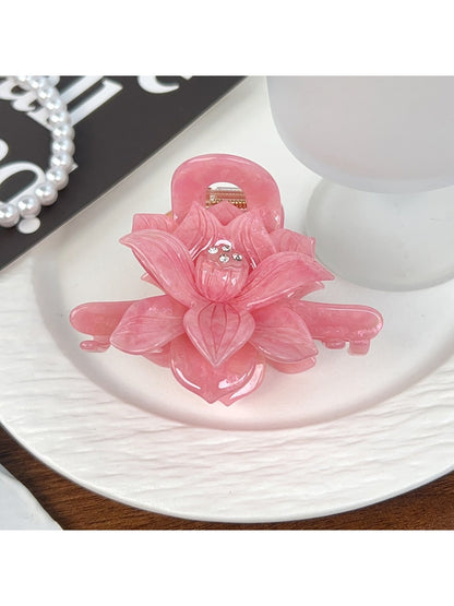 Top view of beige lotus shaped hair claw clip with petal details