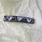 Purple square hair clip clipped into short brown hair