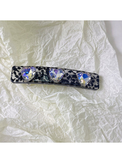Purple square hair clip clipped into short brown hair