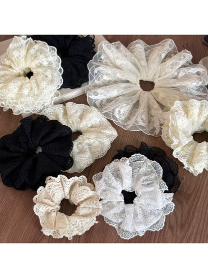 Close-up of Gifty delicate lace scrunchie in soft beige fabric