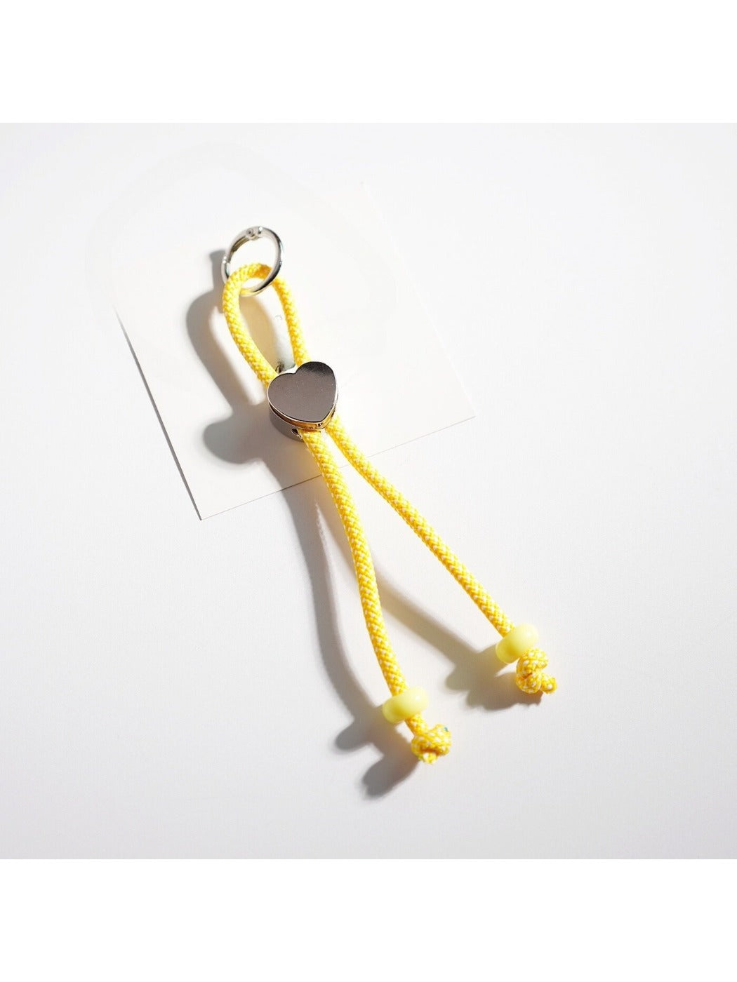 Colorful rope heart keychain held in hand to show size and detail