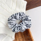 Close-up of a blue scrunchie with a floral print