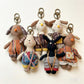 Close-up of the puppy-shaped fabric keychain showing textured fabric and embroidered eyes