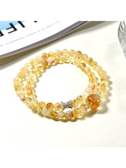Close-up of Lovra yellow crystal beads and gold accents on multi-wrap bracelet