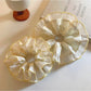 Yellow pleated scrunchie with floral print on white background